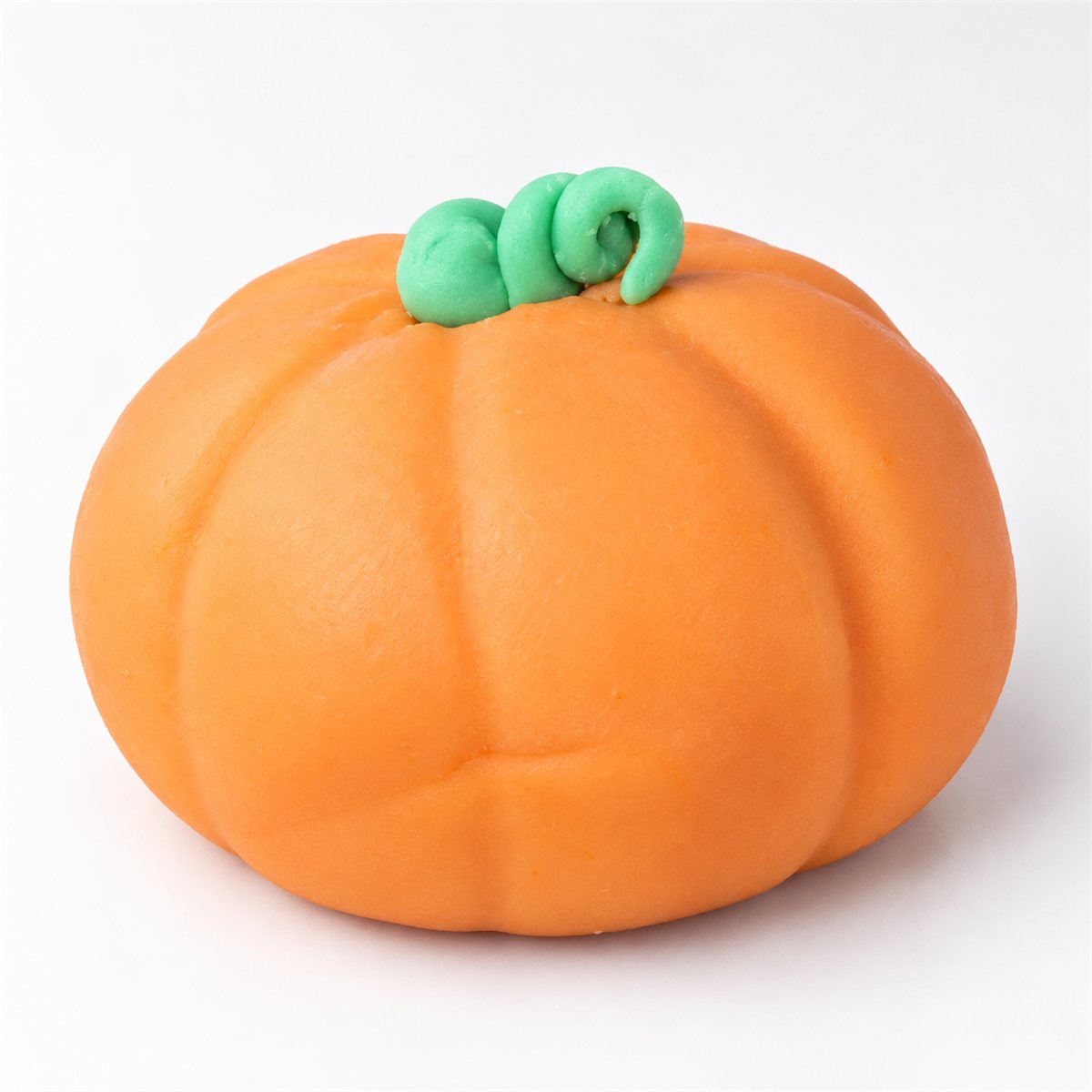 An orange pumpkin-design pie with rounded grooves and a small curled green stem on white.
